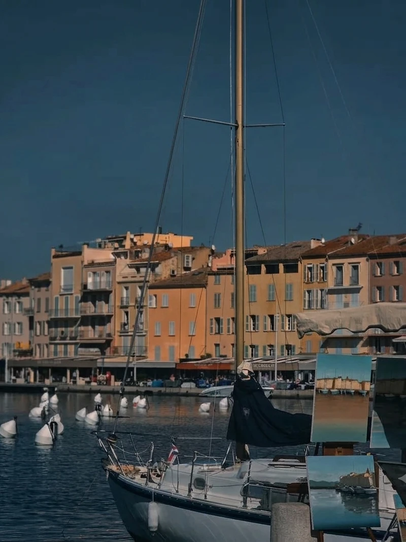 Deep blue sky over the colourful harbourside buildings and sailboat mast in Saint-Tropez old port